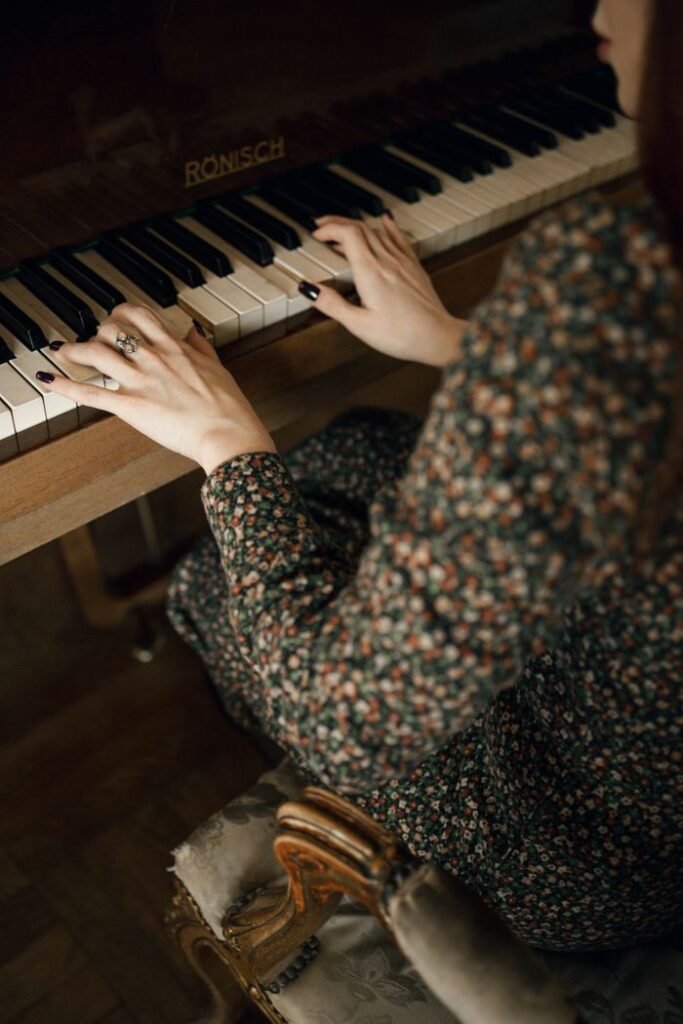 A woman elegantly plays a vintage Rönisch piano indoors, capturing a classic musical moment.